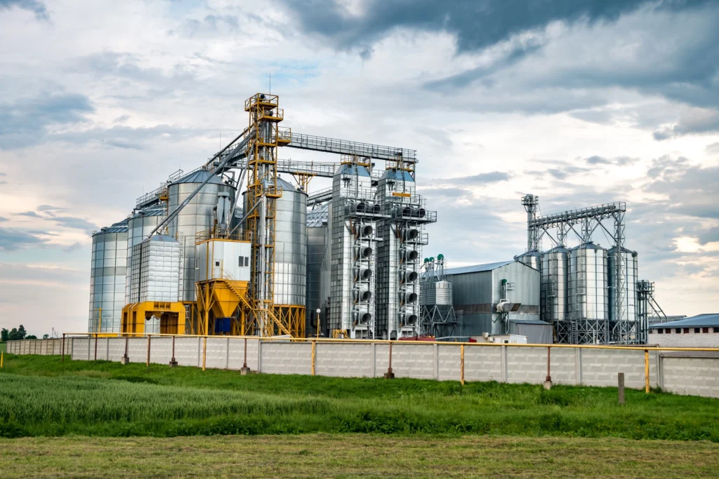 Usina sucroalcooleira com silos e estruturas metálicas industriais.
