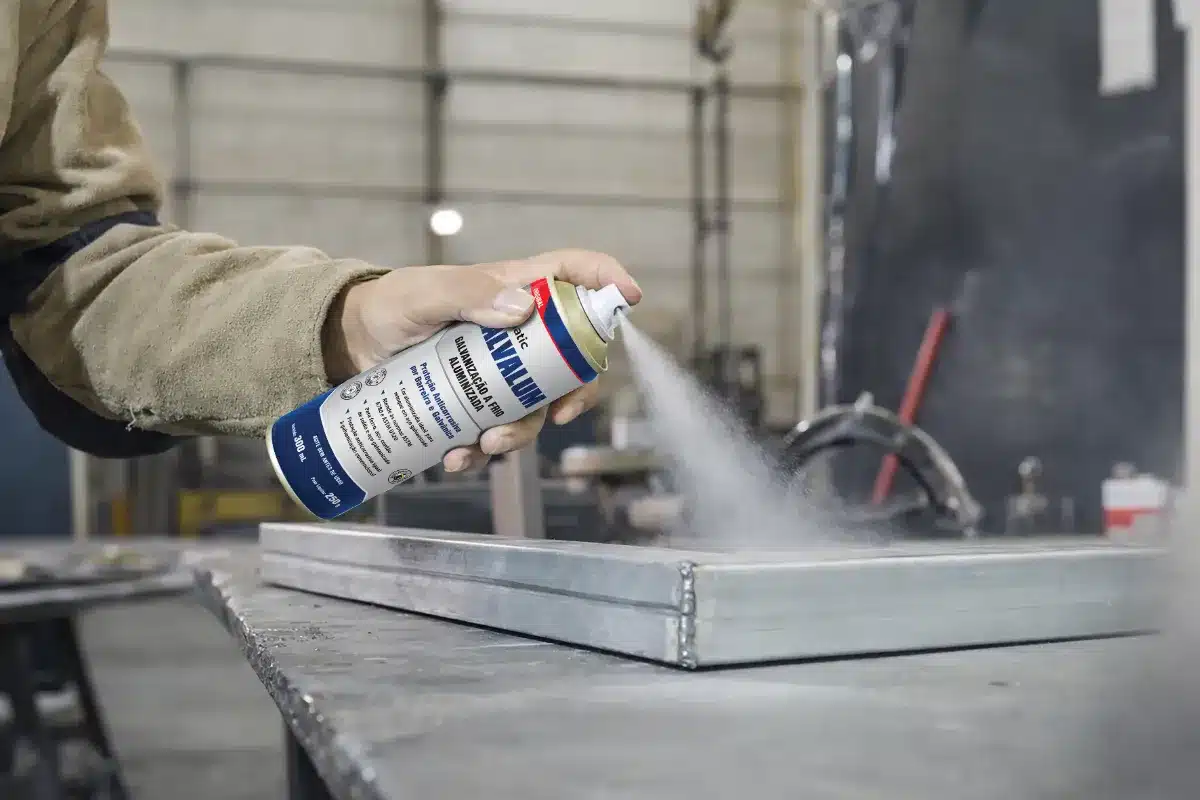 Funcionário na indústria usando desingripante spray